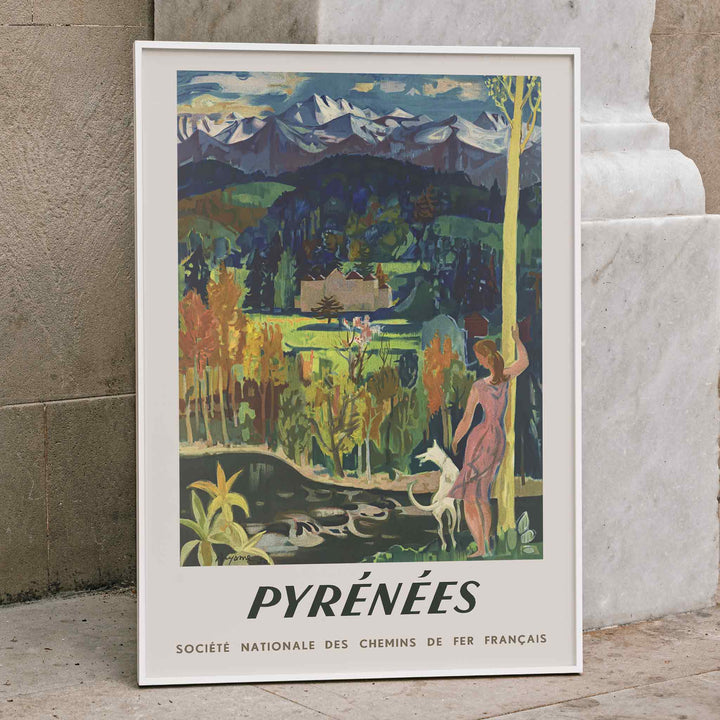 Pyrenees Railway poster by Roger Aujame with alpine peaks, green valley, blue skies, and woman by stream, framed and displayed in home decor