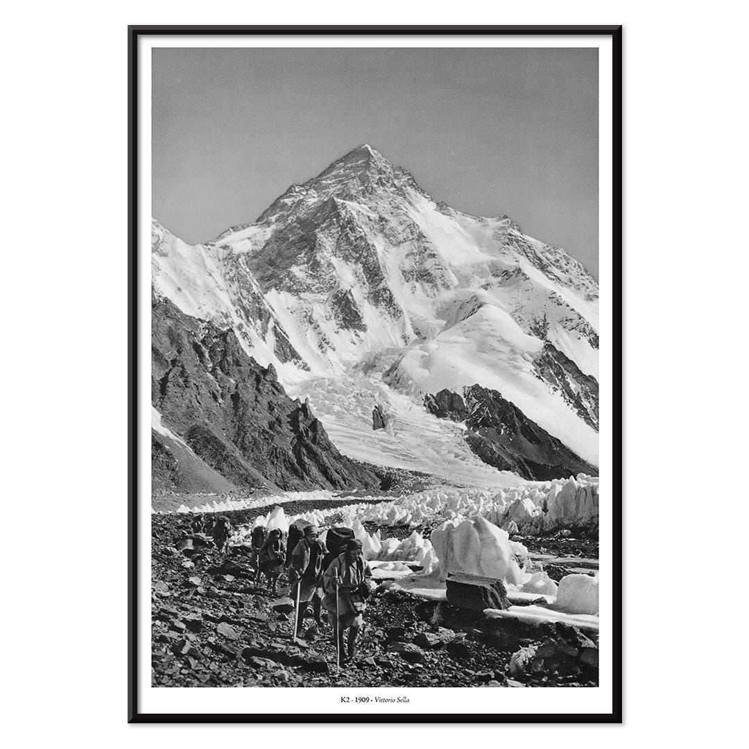 Black and white photo by Vittorio Sella of mountaineers trekking toward K2 over the Godwin Austen glacier titled Le pic K2 vue prise du glacier Godwin Austen, with black aluminium frame on white background