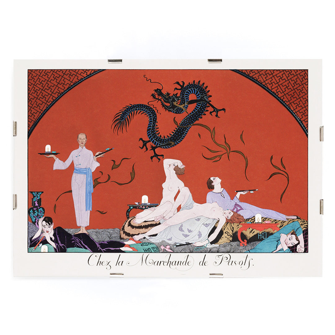 Opulent oriental scene with reclining figures and a blue dragon in Chez la Marchande de Pavots by George Barbier poster on a red background, framed and displayed in modern living room decor