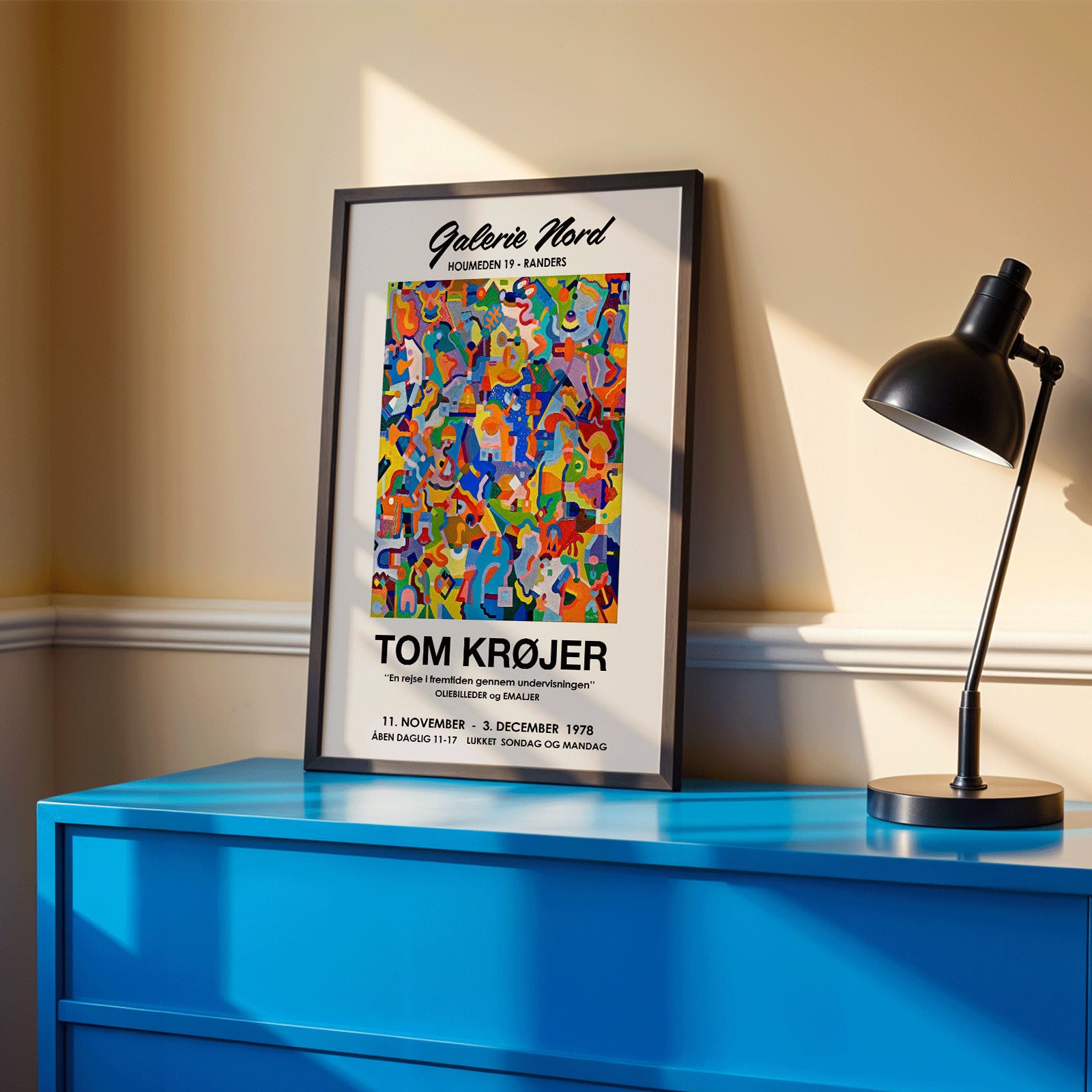 Colorful abstract artwork exhibition poster by Tom Krojer titled En rejse i fremtiden gennem undervisningen at Galerie Nord featuring bold geometric shapes, framed and displayed in modern living room decor