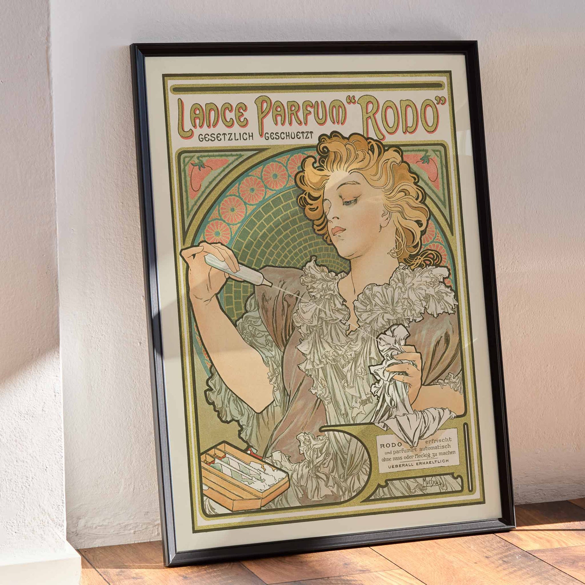 Alphonse Mucha Lance parfum Rodo poster Art Nouveau woman with flowing hair floral border soft green gold tones, framed and displayed in modern living room decor
