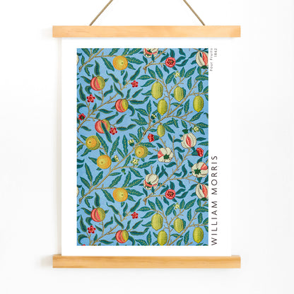 Colorful botanical wallpaper and poster featuring fruits and leaves from Four Fruits pattern by William Morris on blue background for wall decor, with wooden magnetic frame on white background