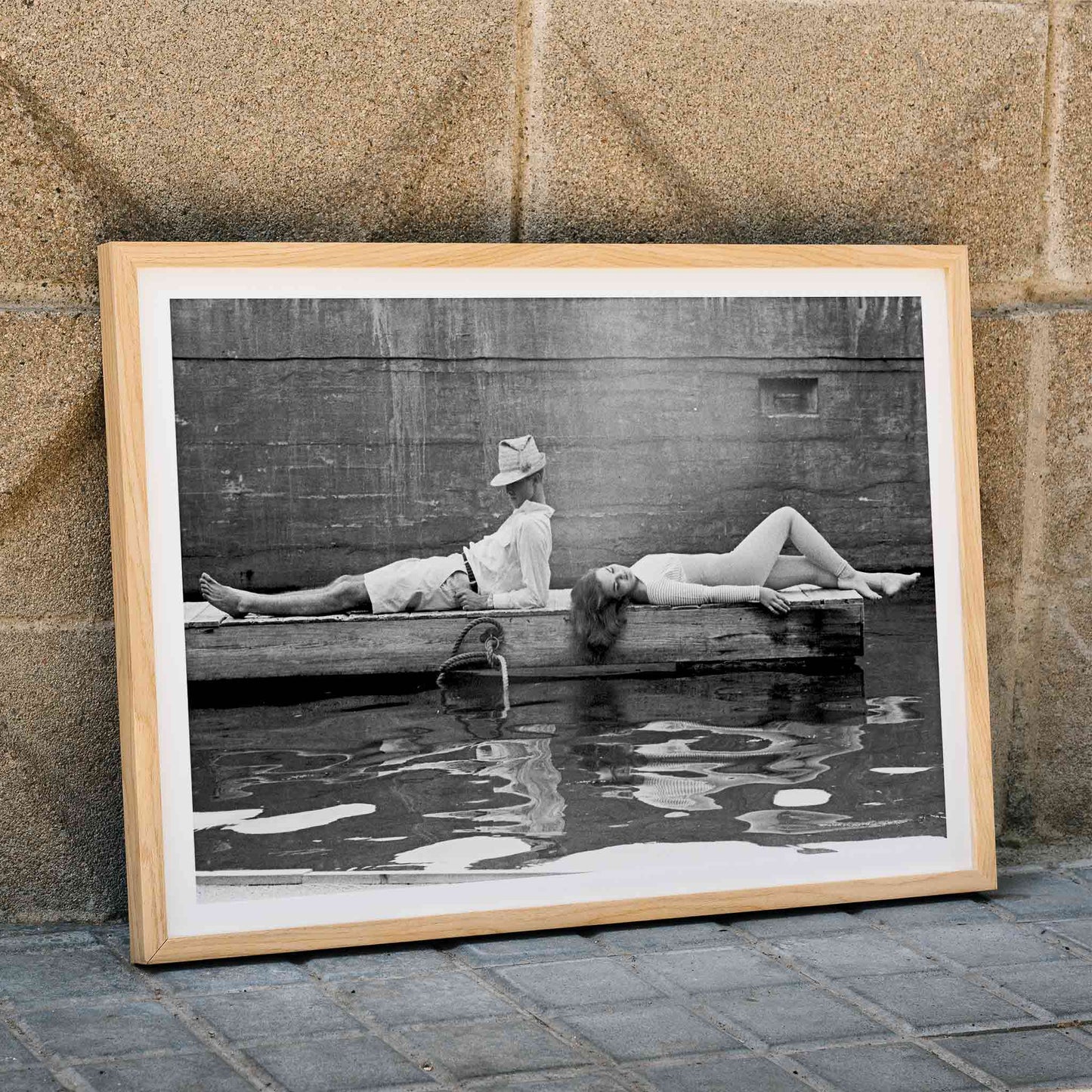 Marquess of Tavistock Henry Robin Ian Russell and Henrietta Tiarks relaxing on a dock in Bermuda by Toni Frissell poster, framed and displayed in home decor