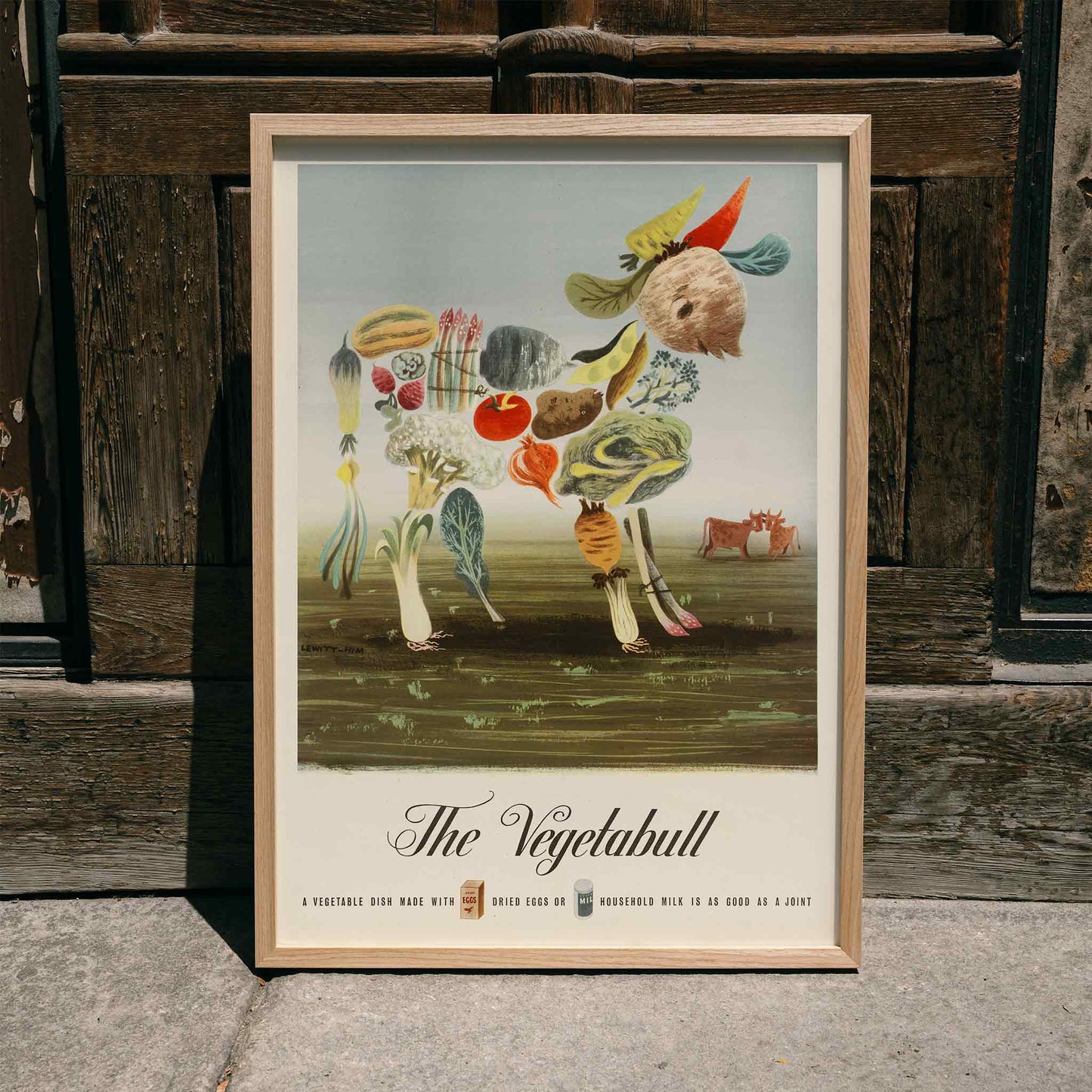 The Vegetabull by Lewitt-Him painting and poster showing a bull made of vegetables on grass background, framed and displayed in home decor